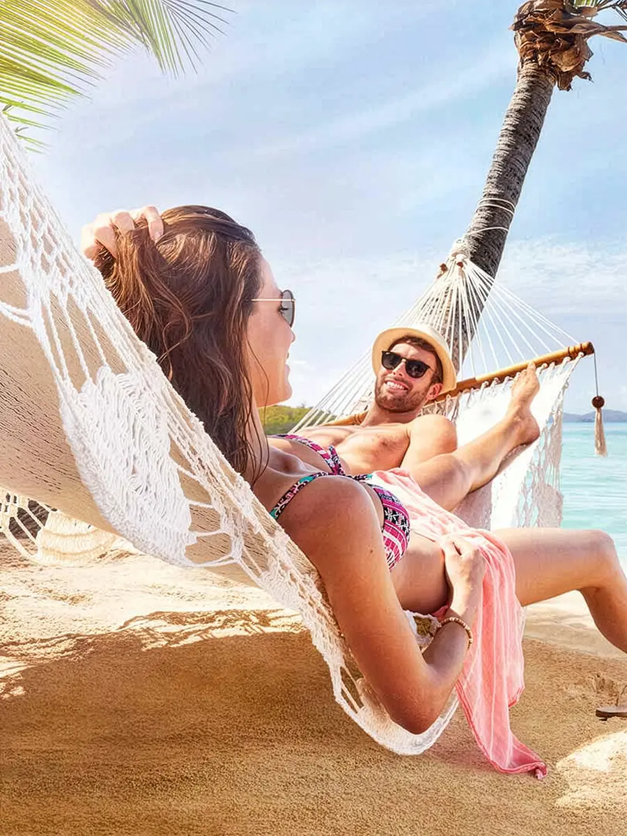 A couple relaxing in a hammock on a beach in Fiji