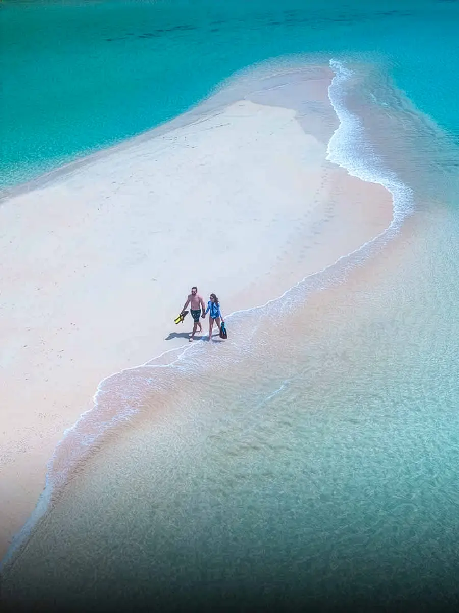 A couple walking on a sand cay in Fiji
